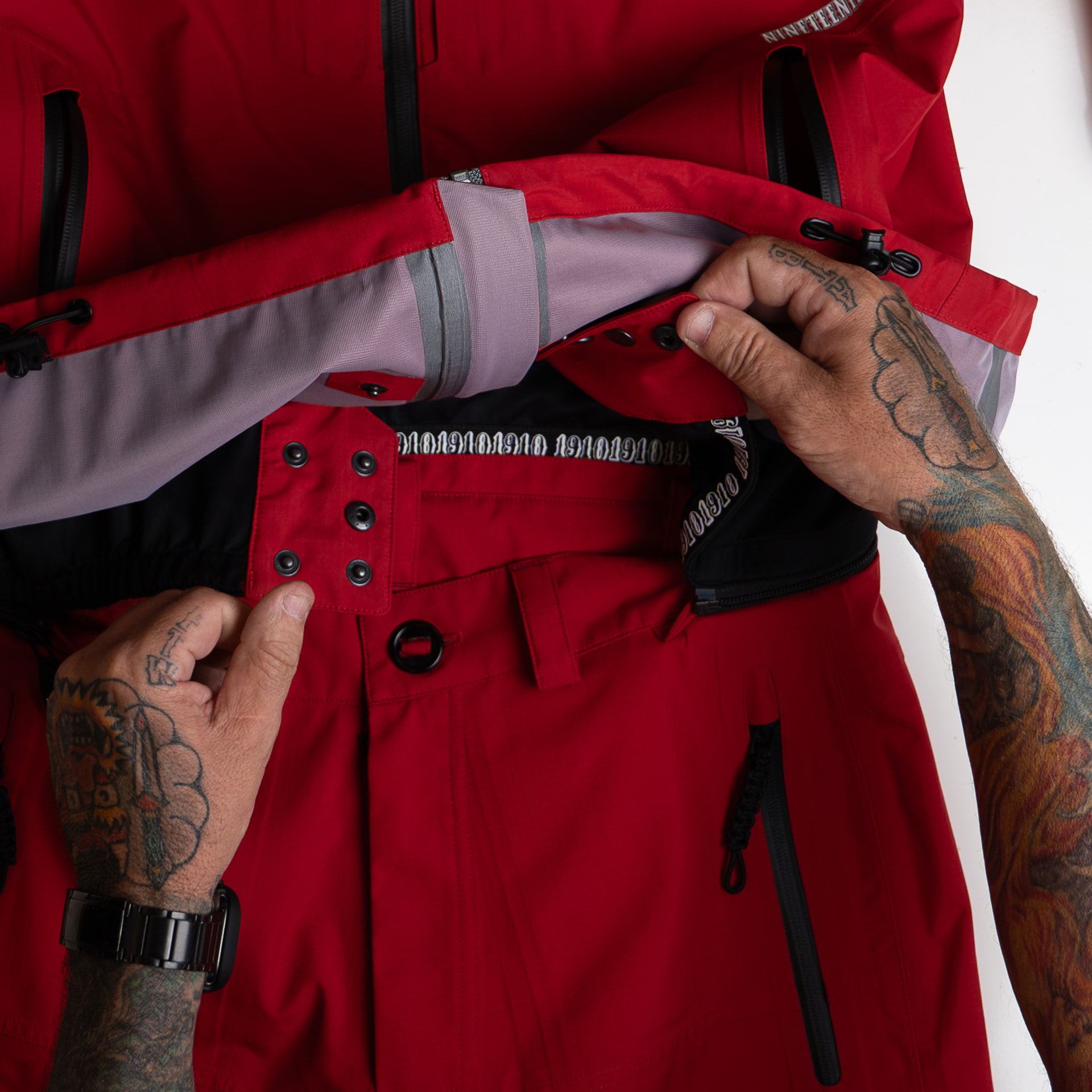Detail of the jacket hem snapped and zipped onto the pant waistband