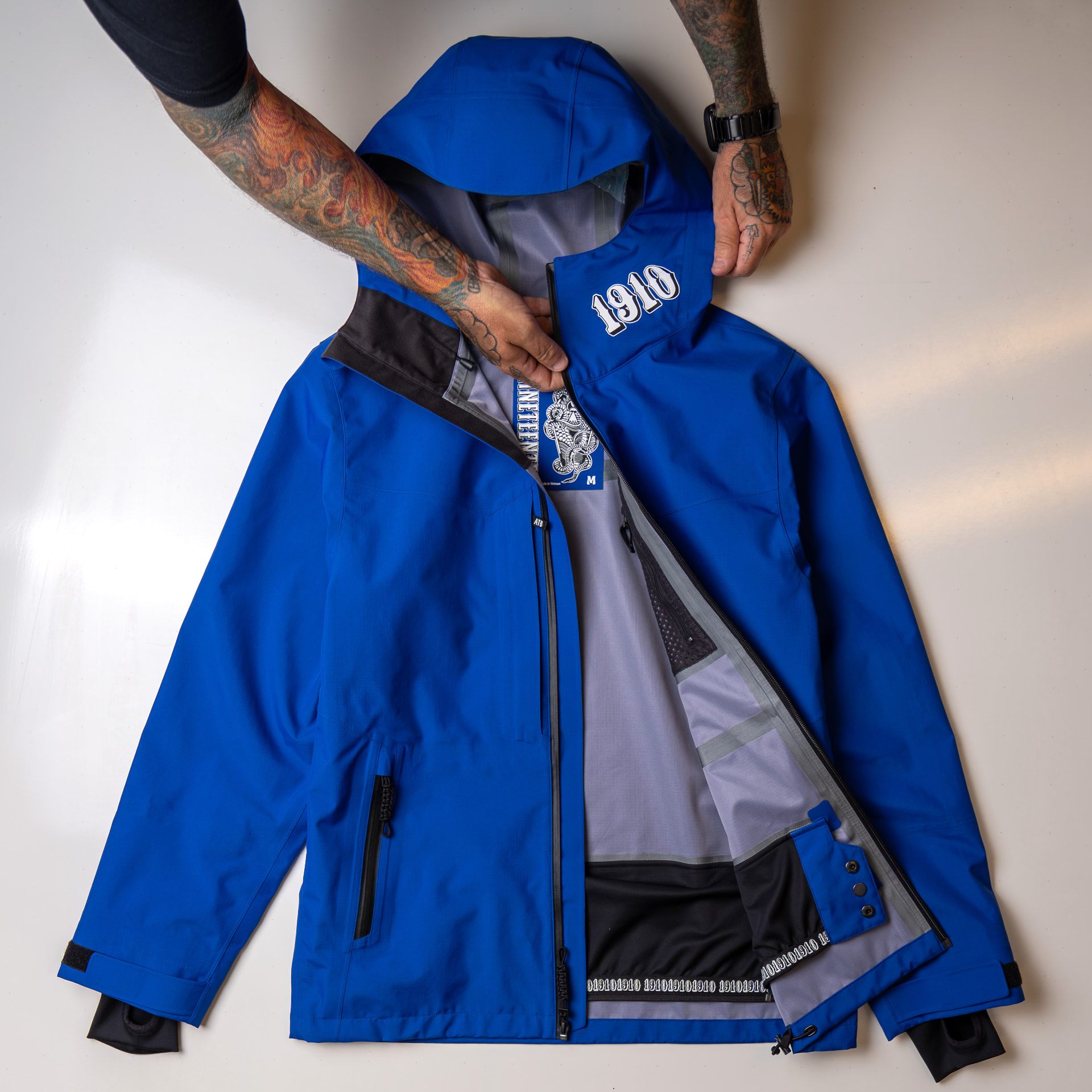 1910 Auburn Jacket in Thaylo Blue, opened to show its interior and collar logo